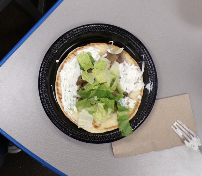 A classic gyro from Dino’s Gyros, featuring seasoned meat, tzatziki, fresh lettuce, and warm pita bread.