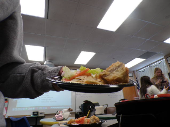 The pita bread is topped with crispy lettuce and juicy tomato. The illuminating vegetables and meat from the ceiling light reflects the high quality food.