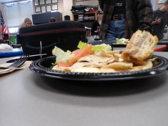 The lettuce, tomato and chicken layer on the plate cohesively. The variety of color and texture emphasize the strong elements in a gyro.