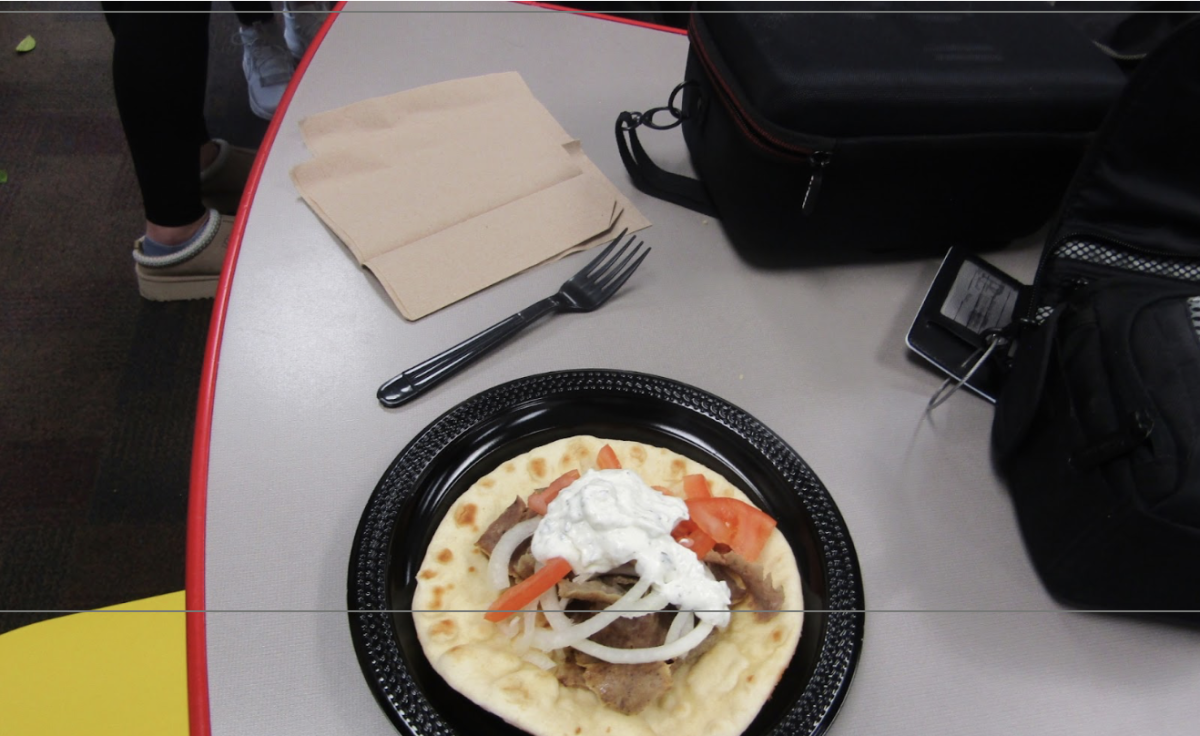 Shot from a high angle, the gyro sits beside a fork and napkin, neatly arranged.