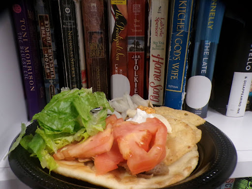 The books in the background really make the food stand out as the lighting is low. The lettuce and tomatoes are really distinct from the things around.