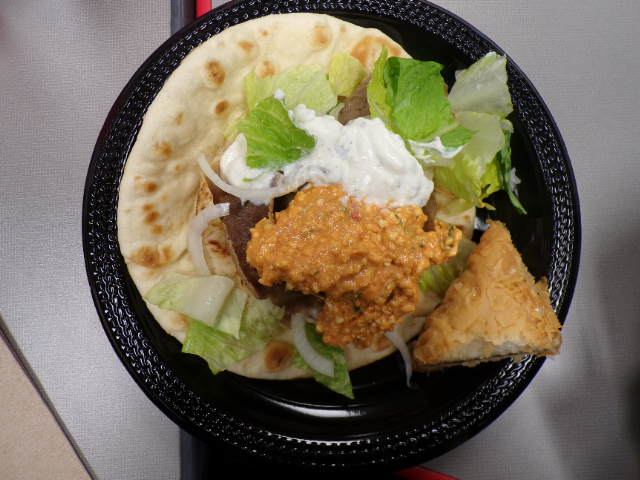 Perfectly balanced gyro filled with feta, tzatziki, lettuce, and onions. Underneath is thinly sliced meat, including lamb and chicken