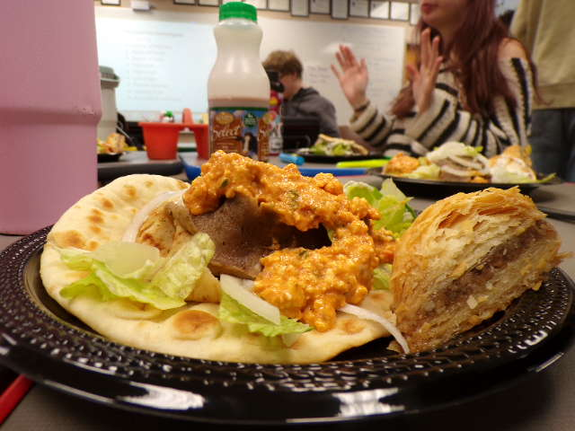 Full plate of Greek food from Dino's Gyros. Baklava and gyro to perfectly fill your hunger with flavorful food. 