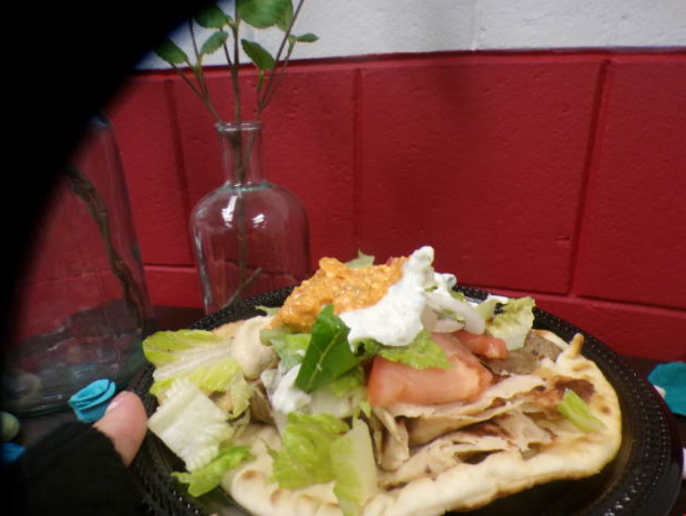 This view calls attention to the lightweight cloud like pita bread with the assorted toppings and juicy meats. You get insight on the thick breading with well cut tomatoes and the whipped mix of sauces.