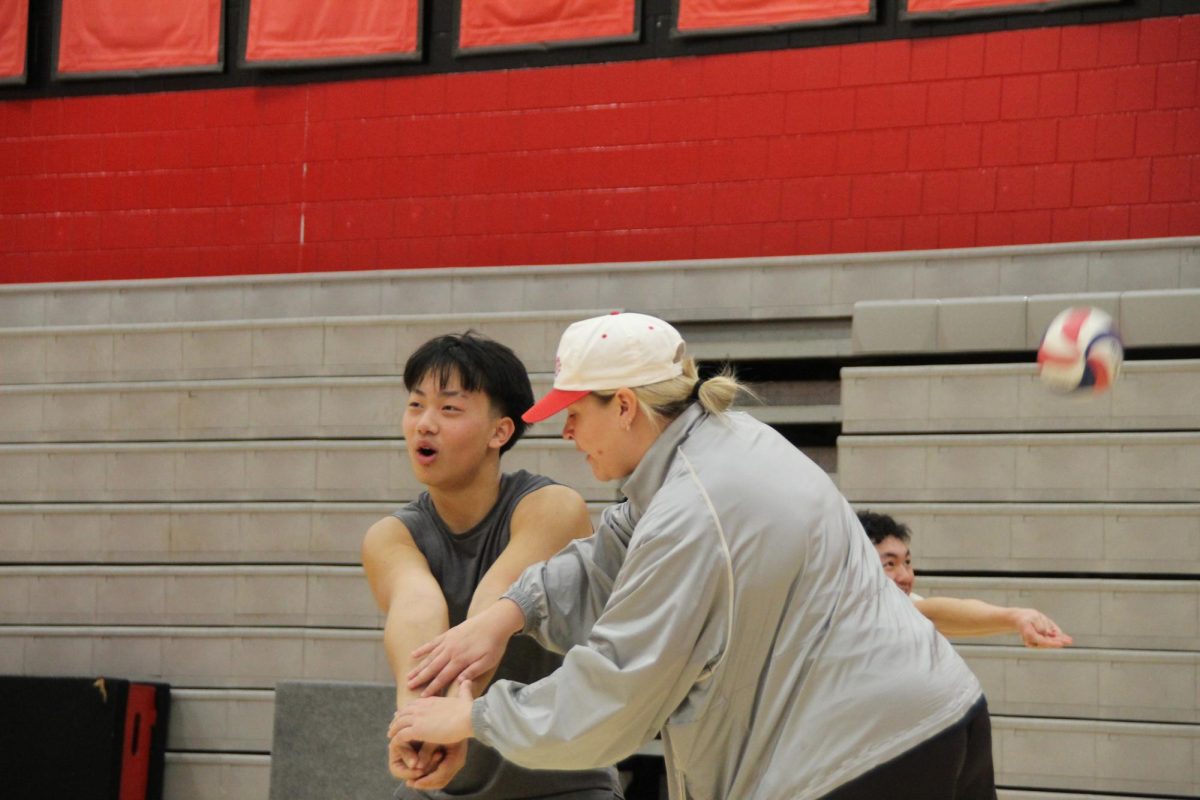 Boys Volleyball head coach Tess Kovala correcting how to form a proper platform to pass a volleyball accurately to a target. Coaching the boys volleyball team to a high standard to obtain success in the upcoming season.